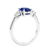 Oval cut three stone real blue sapphire and diamond engagement ring with romantic charm.