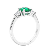 Oval cut three stone real colombian emerald and diamond engagement ring with romantic charm.