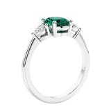 Oval cut three stone real green emerald and diamond engagement ring with romantic charm.