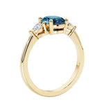 3 stone wedding ring with oval center gemstone and pear shape diamond side stones.