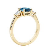 3 stone wedding ring with oval center gemstone and pear shape diamond side stones.