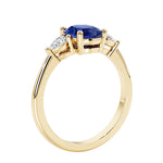 3 stone wedding ring with oval center gemstone and pear shape diamond side stones.