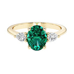 Oval and pear shape 3 stone engagement ring with green emerald and brilliant diamond side stones.