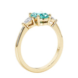 3 stone wedding ring with oval center gemstone and pear shape diamond side stones.