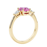 3 stone wedding ring with oval center gemstone and pear shape diamond side stones.