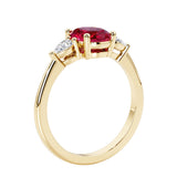 3 stone wedding ring with oval center gemstone and pear shape diamond side stones.