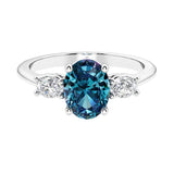 Three stone oval cut diamond ring in classic design featuring alexandrite center.