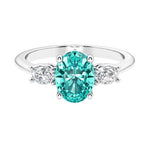 Three stone oval cut diamond ring in classic design featuring paraiba tourmaline center.