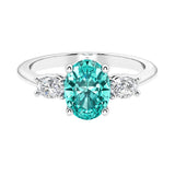 Three stone oval cut diamond ring in classic design featuring paraiba tourmaline center.