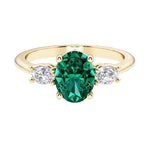 Oval 3 stone engagement ring with real emerald and brilliant diamond side stones.