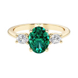 Oval 3 stone engagement ring with real emerald and brilliant diamond side stones.