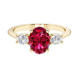 Oval cut three stone diamond engagement ring with romantic charm with gemstone center.