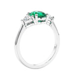 3 stone oval ring with green gemstone and diamonds in sleek white gold.