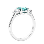 3 stone oval ring with green gemstone and diamonds in sleek white gold.