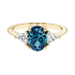 Oval cut three stone diamond engagement ring with romantic charm with gemstone center 14k yellow gold