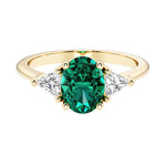 Oval cut three stone diamond engagement ring with romantic charm with green gemstone center 14k yellow gold