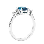 3 stone oval ring with gemstone and diamonds in sleek white gold.
