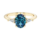 Oval cut three stone alexandrite engagement ring with diamonds set yellow gold.