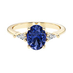 Oval cut three stone alexandrite engagement ring with diamonds set yellow gold.