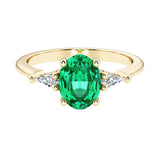 Oval cut three stone alexandrite engagement ring with diamonds set yellow gold.