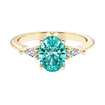 Oval cut three stone paraiba tourmaline engagement ring with diamonds set yellow gold.