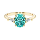 Oval cut three stone paraiba tourmaline engagement ring with diamonds set yellow gold.