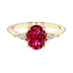 Oval cut three stone ruby engagement ring with diamonds set yellow gold.