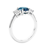 Engagement ring with oval shaped gemstone and diamonds in a 3 stone design.