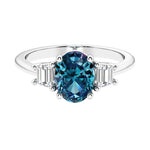 Oval cut three stone diamond engagement ring with romantic charm.