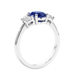 Engagement ring with oval shaped blue gemstone and diamonds in a 3 stone design.