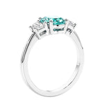 Engagement ring with oval shaped green gemstone and diamonds in a 3 stone design.