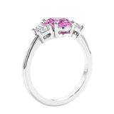 Engagement ring with oval shaped pink gemstone and diamonds in a 3 stone design.