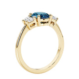 3 stone wedding ring with oval center gemstone and diamond side stones.