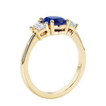 3 stone wedding ring with oval center blue gemstone and diamond side stones.