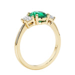 3 stone wedding ring with oval center green gemstone and diamond side stones.