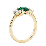3 stone wedding ring with oval center green gemstone and diamond side stones.