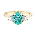 3 stone oval engagement ring with elegant proportions with green gemstone and diamonds.