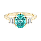 3 stone oval engagement ring with elegant proportions with green gemstone and diamonds.