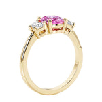 3 stone wedding ring with oval center pink gemstone and diamond side stones.