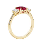 3 stone wedding ring with oval center red gemstone and diamond side stones.