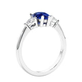 3 stone diamond engagement ring with pear shaped center in white gold featuring Blue Sapphire.