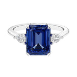 Three stone emerald cut engagement ring for timeless elegance featuring gemstone and diamonds.