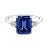 Three stone emerald cut engagement ring for timeless elegance featuring gemstone and diamonds.