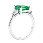 3 stone emerald cut diamond ring in modern gold setting with gemstone center.