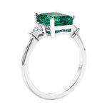 3 stone emerald cut diamond ring in modern gold setting with gemstone center.