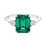 Three stone emerald cut engagement ring for timeless elegance featuring gemstone and diamonds.