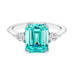 Three stone emerald cut engagement ring for timeless elegance featuring gemstone and diamonds.