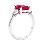 3 stone emerald cut diamond ring in modern gold setting with gemstone center.