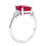 3 stone emerald cut diamond ring in modern gold setting with gemstone center.