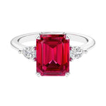 Three stone emerald cut engagement ring for timeless elegance featuring gemstone and diamonds.